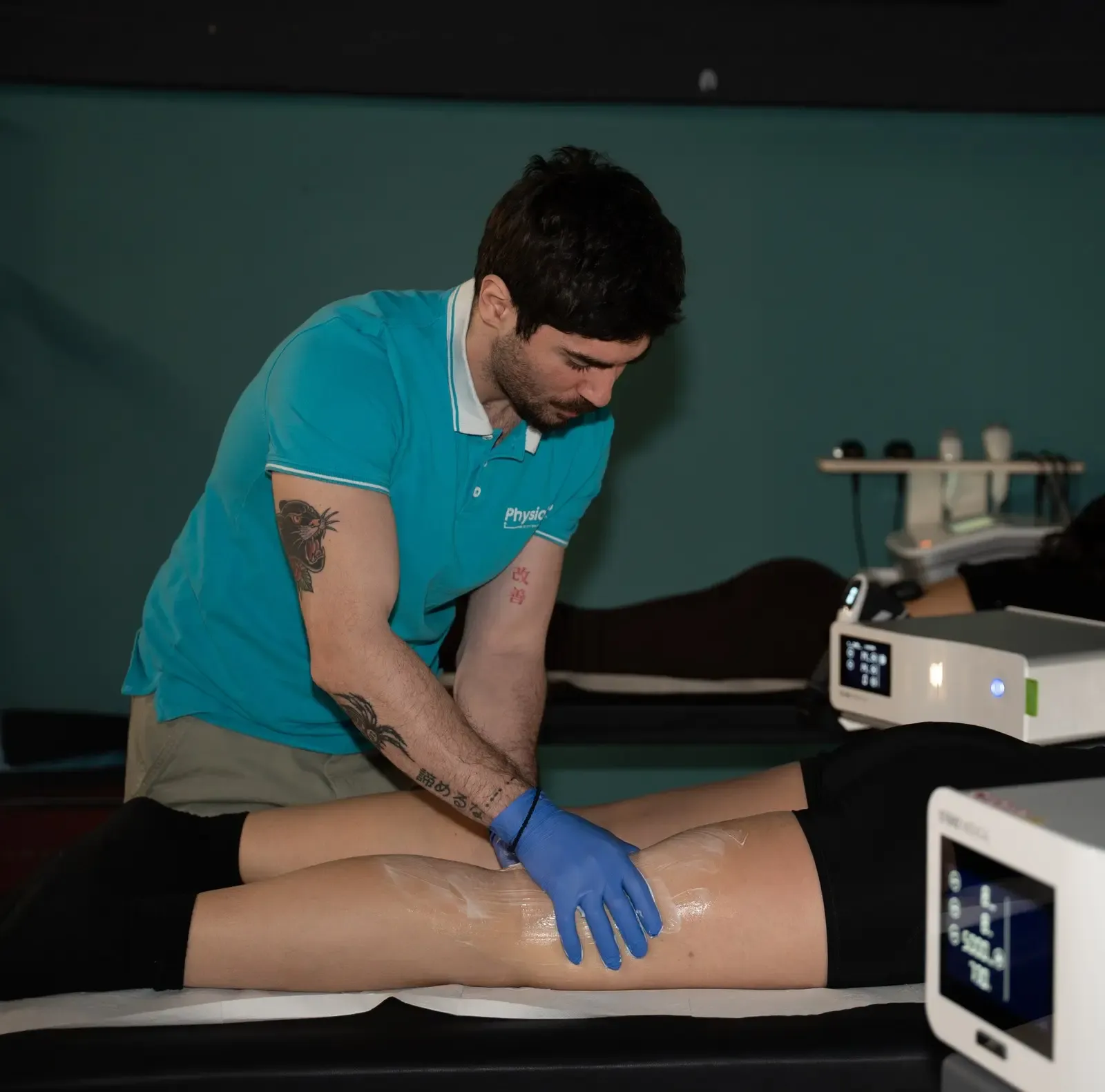 PhysioHub-ის ფიზიოთერაპევტი პაციენტს ბარძაყის მკურნალობას უტარებს კლინიკაში